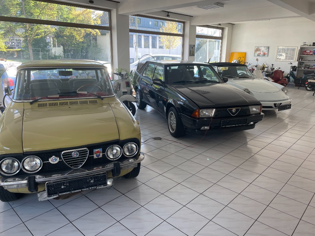 Klassische Automobile und Roller im Showroom, italienische Fahrzeuge